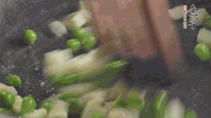 鍋中油7成熱時(shí)，入青豆、筍丁翻炒，然后加糯米飯加鹽均勻翻炒。