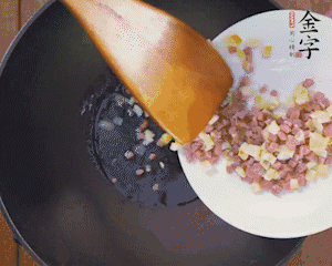 油溫3成熱時(shí)，下火腿丁、筍丁炒出香味，放豌豆粒翻炒均勻2分鐘。