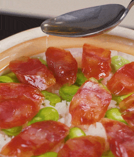 大米出現(xiàn)小孔時(shí)開(kāi)蓋放香腸，往鍋邊淋入少許油，再燜煮8~10分鐘左右。