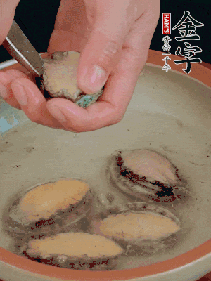 鮑魚加鹽、清水浸泡，用勺子挖出鮑魚肉。
