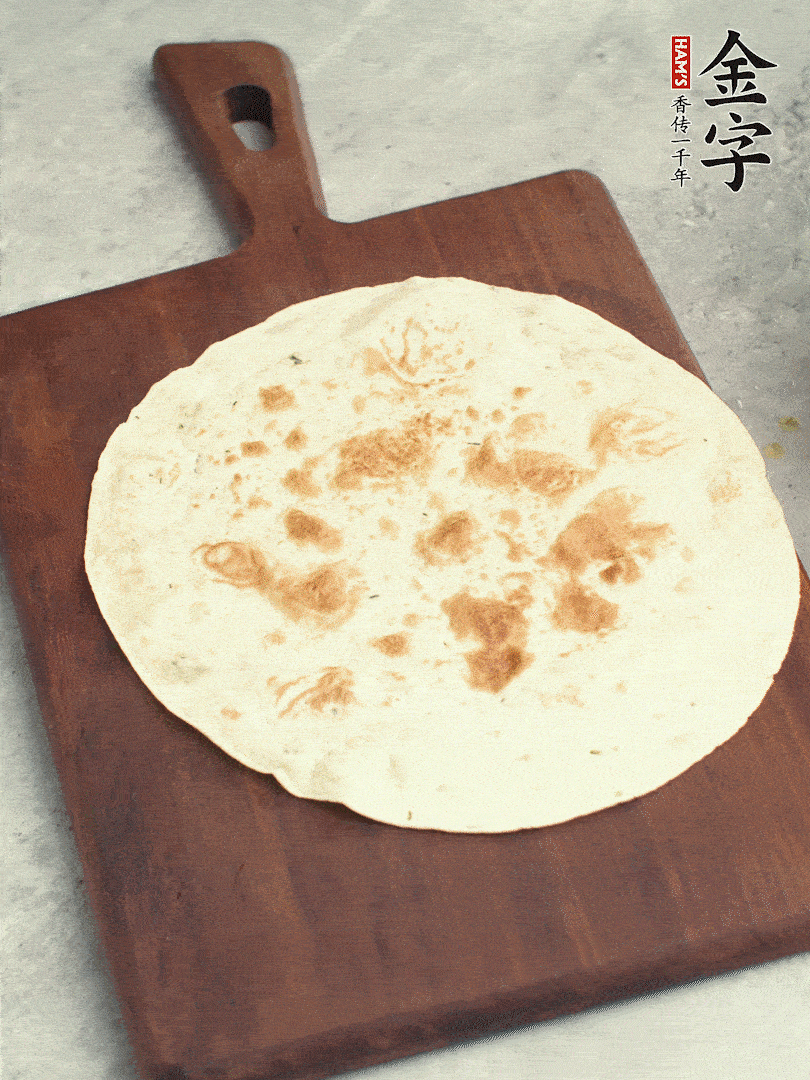 食材依次鋪在卷餅皮上，卷起來。