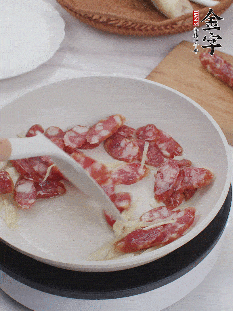 油溫3成熱時，下姜絲、蒜片、香腸炒出油脂。