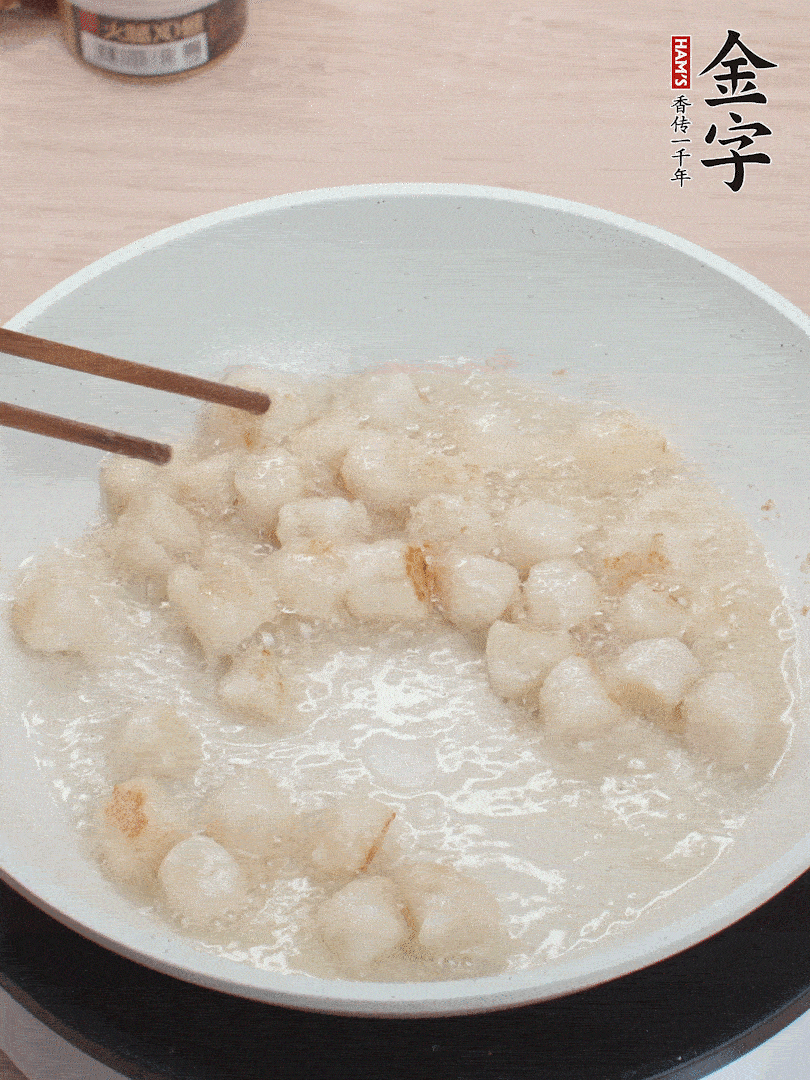 油溫4成熱，鮮貝蘸干淀粉下鍋煎，一面微黃后翻面。