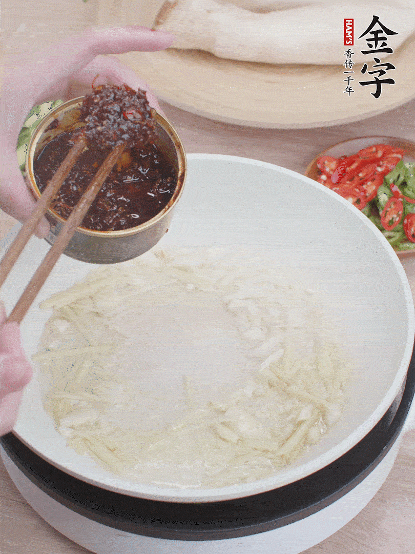 起鍋熱油，姜蒜、金字火腿干貝醬煸香。