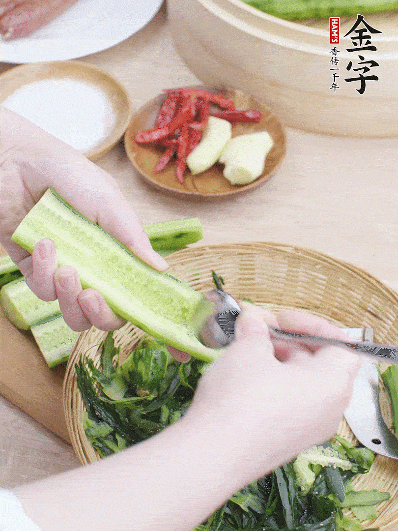 黃瓜削皮，對半切開，勺子挖去內(nèi)瓤，斜刀切片。青蒜斜刀切段。