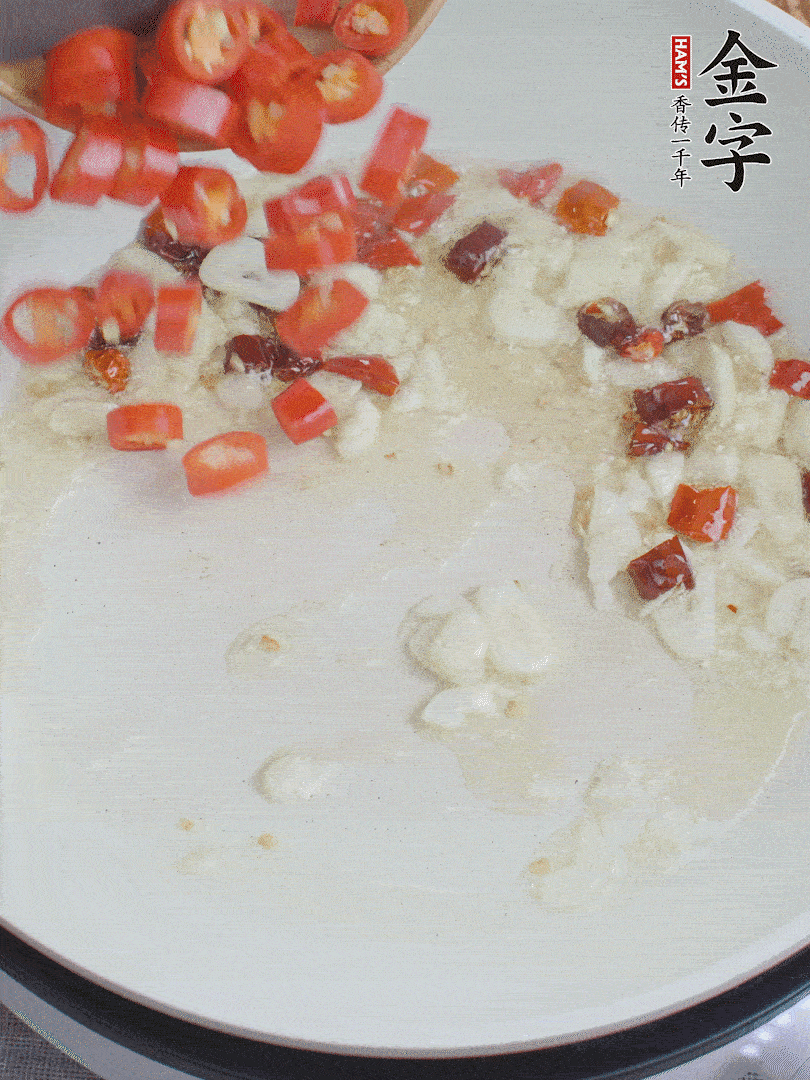 油6成熱，下蒜末、干紅辣椒煸炒，出香味后再放美人椒、香腸。