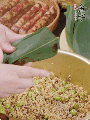 粽葉往下折，完全蓋住，兩側(cè)捏緊。