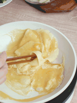 油6成熱時，下雞蛋液，邊緣凝固時翻拌成塊狀。