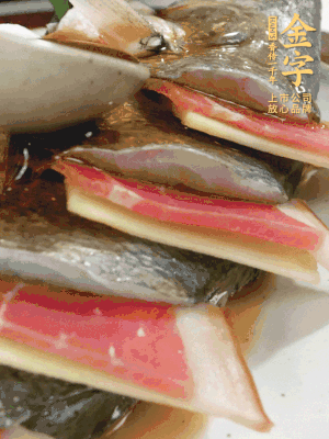 魚肚中塞蔥結(jié)、火腿片，魚身上碼放姜片、火腿片，倒入混合的料汁。