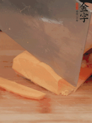 南瓜改刀切片，把蒸好的火腿鋪到南瓜上。