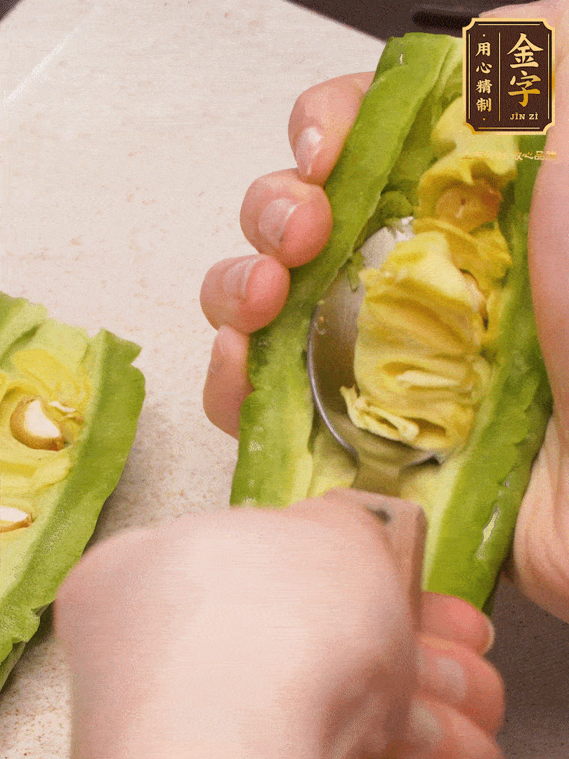 苦瓜從中間切開，把里面的瓢和籽全部挖干凈