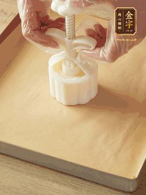 取一個面團，捏扁，中間厚，四周薄。虎口往上推，直到收口，把餅胚放入模具里，壓2-3下