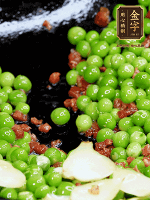 鍋內(nèi)少許油，下火腿煸香，再下甜豆米、百合翻炒，少許鹽、一點水煮到收干