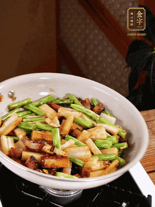 油熱下蒜末、干辣椒、醬肉煸炒出香味，依次下藕條、豆角翻炒均勻